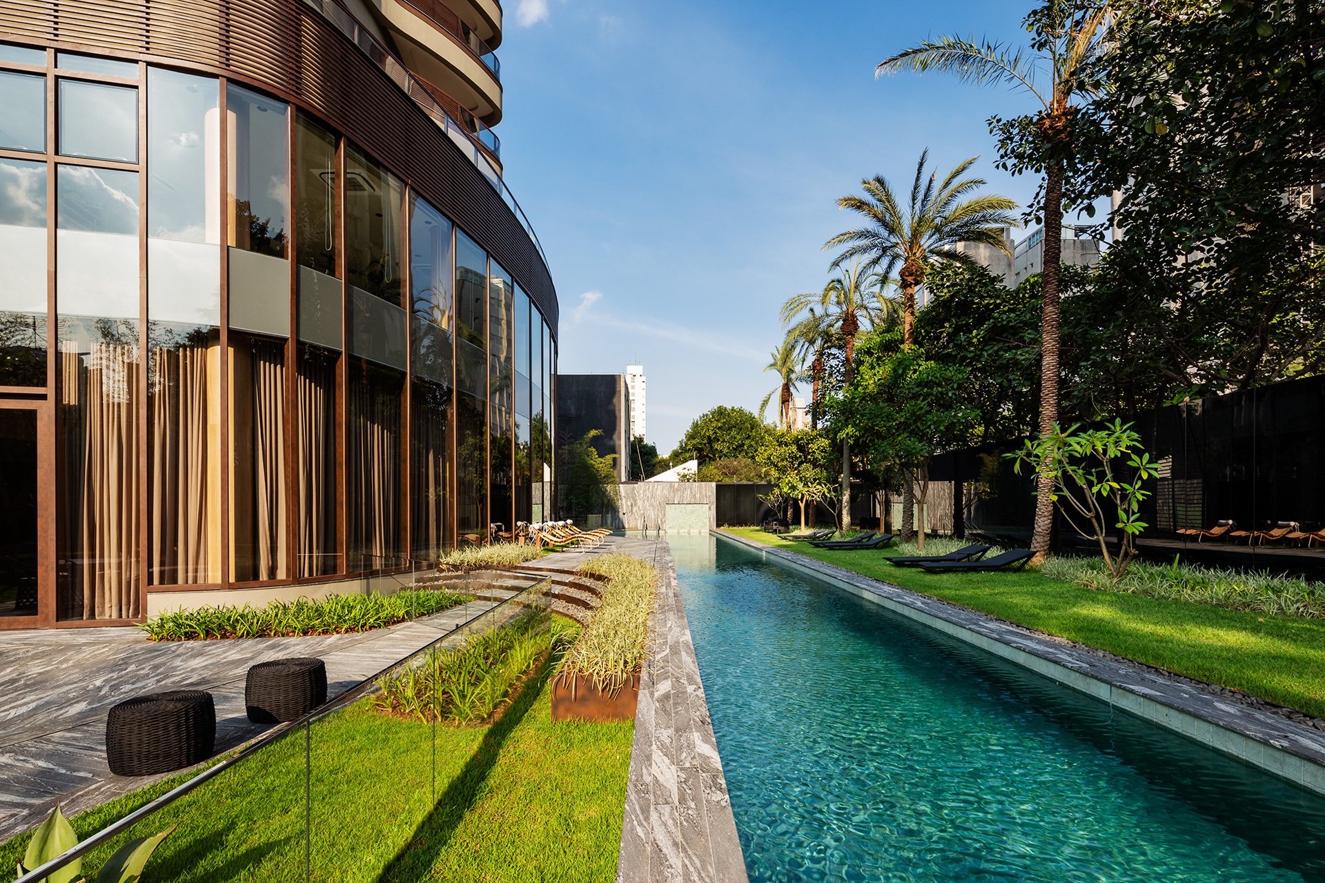 Piscina com raia e jardins à luz do dia